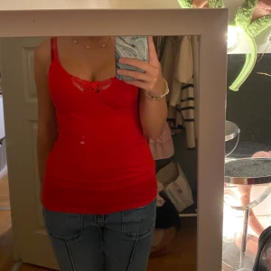 Röd spetsdetaljerad linnetopp - Säljer en röd linnetopp med smala axelband och snygga spetsdetaljer vid urringningen. 💕💕