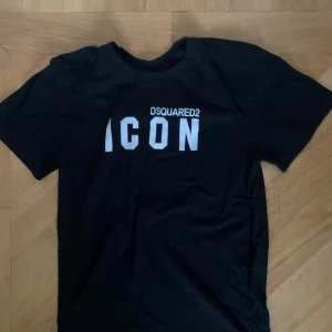 Svart Dsquared2 ICON t-shirt - Svart t-shirt från Dsquared2 med stor vit 'ICON'-text och logga på bröstet.