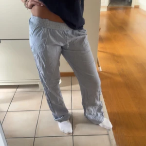 Ljusblå randiga linnebyxor med resår - Byxorna är från märket (neo Noir)🩷 Säljer ett par ljusblå linnebyxor med tunna vita ränder. Byxorna har resår i midjan och en avslappnad, loose passform. 