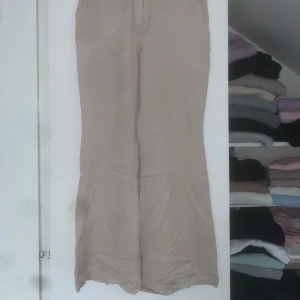 Beiga linnebyxor  - Snygga beiga linnebyxor från H&M i storlek 36. Byxorna har raka ben, hög midja och stängs med både hake och knapp.