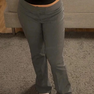 Grå kostymbyxor med bootcut - Snygga gråa kostymbyxor – storlek 40  Fräscha kostymbyxor i klassiskt grått. Endast använda ett fåtal gånger och i mycket fint skick – ser nästan helt oanvända ut. Inga skador eller slitningar.  Jag har själv storlek 38 och de sitter riktigt bra både i midjan och på längden, så de passar även om du brukar ha 38. Perfekta både till jobbet och festligare tillfällen!  📏 Storlek: 40 (passar även 38) 🎨 Färg: Grå 👖 Skick: Mycket bra, nästan nya 