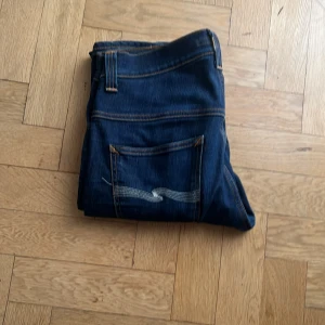 Nudie jeans - Nudie jeans använda ett fåtal gånger. Inga defekter skick 10/10. Färgen är en mörk blå. Storlek W34 L30 men är små i storleken så passar någon runt 170. Modellen är Thinn Fin och passformen är slimfit.