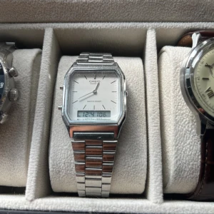 Casio digital-analog klocka silver - Klassisk Casio klocka i silverfärgat rostfritt stål med både digital och analog display. Rektangulärt ur med vit urtavla, smala visare och länkarmband. Perfekt för dig som gillar retrostil och enkel design.