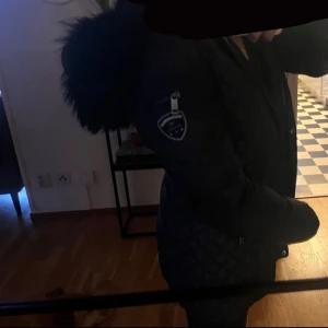 Svart pufferjacka Rockandblue 36 - Säljer en svart pufferjacka från Rockandblue i storlek 36. Den har två defekter ena är att dragkedjan ej fungerar utan då har jag använt mig utav knapparna för att stänga den. Ena fickan inuti jackan är också trasig. Säljs därför mycket billig, har endast använts en vinter.