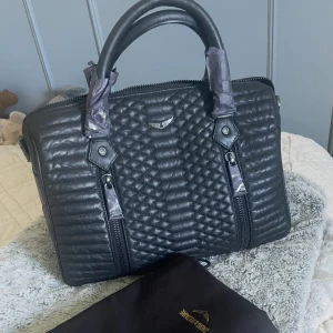 Zadig & Voltaire Sunny bag medium - Zadig & Voltaire väska i storlek medium (största storleken) och är i bra skick💕 väldigt rymlig och man får plats med dator i så perfekt för skolan💕 finns lite tecken på användning som syns på sista bilden (lite slitning på dragkedja och lite grann i lädret vid dragkedjan)💕 skulle säga att den är väldigt bra skick och dem små slitagen är absolut inget som syns vid användning🥰 axelrem tillkommer och dustbag 💕köpte för ish 6000kr och den säljs inte längre i dethär materialet💕