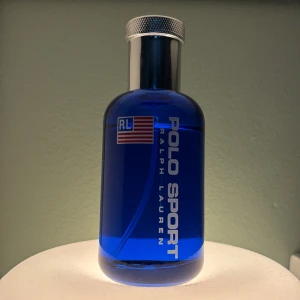 Polo Sport Eau de Toilette 125 ml - Fräsch och sportig parfym från Ralph Lauren i en stilren blå glasflaska med silverfärgad metallkork. Flaskan rymmer 125 ml och har tydlig Polo Sport-logga samt amerikansk flagga på framsidan. Perfekt för dig som gillar energiska och maskulina dofter.