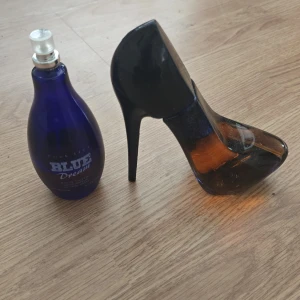 Parfym Blue Dream & stilettflaska - Säljer två parfymer: en Blue Dream i blå glasflaska med spraykork och en parfym i form av en stilettklack i svart och bärnstensfärgat glas. Perfekt för dig som gillar snygga och annorlunda flaskor att ha på hyllan. Den blå är gammal #retro #vintage och saknar kork. 