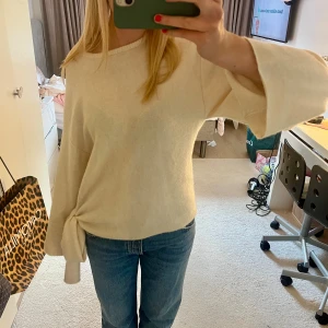 Beige stickad tröja med knyt i sidan🤩🤩 - Superfin beige stickad tröja med breda ärmar och snygg knytdetalj i sidan. Den är sparsamt använd och i toppskick!! Så cool!🤩🤩