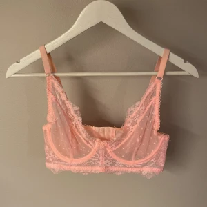 Rosa spetsig blus med prickar från Cubus - Söt och feminin rosa BH i mesh och spets med små prickar. Justerbara axelband och fina spetsdetaljer längs kanterna. BH:n har hakknäppning bak och transparent material som ger en lätt och luftig känsla. 