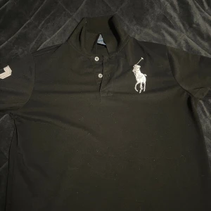 Svart Polo Ralph Lauren piké - Svart polo ralph lauren piké, Storlek M (slim fit) Riktigt stilig och snygg! Som nyskick, jättebra kvalité. Finns inga defekter på tröjan! Vid funderingar / prisförslag är de bara att skriva ! 