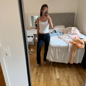 Levis 527 mörkblå bootcut jeans - Mörkblå Levis 527 jeans med bootcut passform och klassiska kontrastsömmar. Jeansen har en snygg, tidlös look. De är en liten fläck på jeansen som man ser på sista bilden och därför säljs de för ett billigare pris då de kostade runt 1000 kr när jag köpte dem🧿