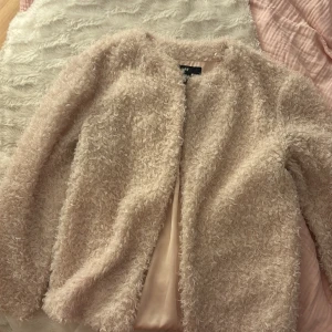 Beige tunnjacka från H&M strl 34 - Säljer en fluffig och mysig tunn höst/vår jacka från H&M i beige ton. Jackan har rund hals, långärmad design och är fodrad med slätt tyg på insidan. Perfekt för dig som gillar en chill och trendig look med extra cozy vibes.