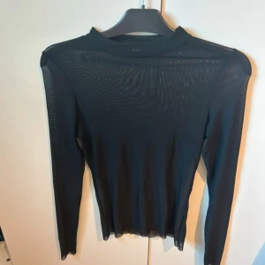 Svart mesh topp - Säljer en svart mesh topp från Bik Bok i storlek XS. Toppen är långärmad och har en tight passform. Materialet är tunt och genomskinligt, perfekt att styla lager på lager. Enkel och stilren design som funkar till många outfits. Tröjan är endast testad!