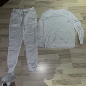 Vit sweatshirt och byxor, Lacoste set - Vit långärmad sweatshirt från Lacoste samt byxor kan även sälja delar individuellt, knappast använda priset kan diskuteras vid snabb affär och har ni några frågor äre bara att skriva.