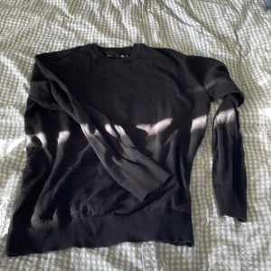 Svart stickad tröja från 157, storlek S - En svart stickad tröja från 157 i storlek S. Tröjan har rund halsringning, långa ärmar och ribbade muddar vid ärmslut och nederkant. Enkel och stilren modell som passar perfekt till lager-på-lager under höst och vinter.