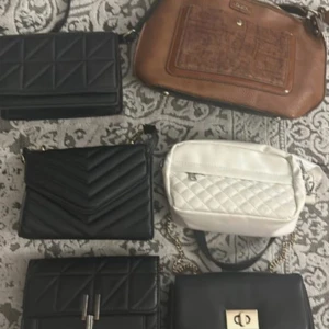 Mix av trendiga axelväskor och kuvertväskor - Säljer ett gäng snygga väskor i svart, vitt och brunt. Flera quiltade modeller med kedjeremmar, en brun väska i skinnlook och en vit quiltad väska. Perfekta för dig som gillar stilrena och moderna accessoarer. 50kr st men går att köpa alla tillsammans också. Pris diskuteras.