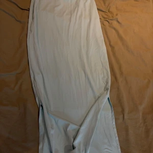 långkjol med slits - Säljer en stilren långkjol med slits på sidan. Kjolen har en tight passform och är tillverkad i ett mjukt, stretchigt material som sitter snyggt på kroppen. Perfekt för dig som gillar minimalistisk och fräsch stil.    Färgen är ”cyan” blågrön? Samma färg som på bild 2 min egen bild fångade inte upp färgen