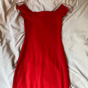 Röd offshoulder klänning Bik Bok XS - Snygg röd offshoulder klänning från Bik Bok i figurnära modell. Klänningen är relativt kort och endast använd någon gång. Perfekt för dig som vill sticka ut med en enkel men stilren outfit.