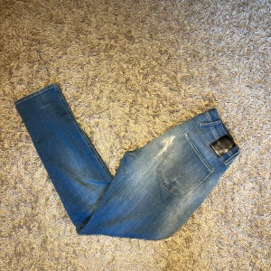 Replay Anbass ljusblå jeans - Säljer ett par Replay Anbass jeans i ljusblå tvätt med snygga slitningar och klassisk femficksdesign. Jeansen har smal passform och normal midja, tillverkade i mjukt jeansmaterial med stretch för extra komfort. Postas antigen samma dag som köp eller dagen därpå🙌💯