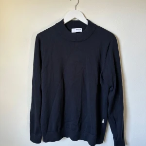 Mörkblå stickad tröja från Selected Homme - En stilren mörkblå stickad tröja från Selected Homme. Tröjan har rund halsringning med bred ribbad kant och långa ärmar. Perfekt för lager-på-lager och funkar året runt. Enkel och klassisk design som passar till det mesta. 3T20