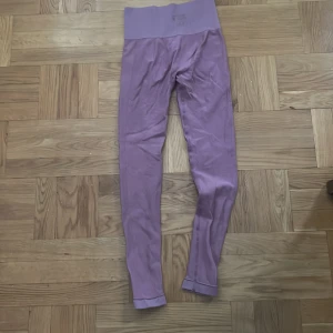 Lila seamless leggings med hög midja - Säljer ett par lila 💜 leggings med bred, ribbad hög midja. De är tighta och har en snygg struktur i materialet som ger en sportig vibe. Perfekta för träning eller chill. Materialet är stretchigt och mjukt för maximal komfort.
