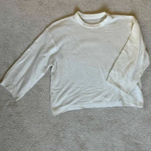 Vit stickad tröja från Lager 157 - Mysig vit stickad tröja från Lager 157 med rund halsringning och avslappnad passform. Tröjan har långa ärmar och är perfekt för lager-på-lager under kyligare dagar. Enkel och stilren design som funkar till det mesta. Tröjan är stor till storleken.