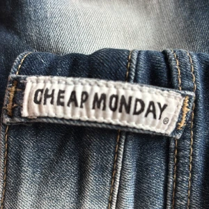Bootcut jeans från Cheap Monday - Oanvända snygga blå bootcut jeans från Cheap Monday med ljusa slitningar framtill och baktill. Klassisk femficksmodell med normal midja och utsvängda ben. 