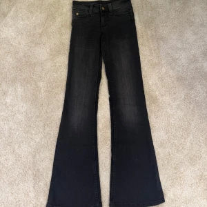 Svarta bootcut jeans från Cheap Monday - Snygga svarta jeans från Cheap Monday med bootcut passform och klassisk femficksdesign. Jeansen har en cool vit patch med Cheap Monday-loggan och döskalle på bakfickan. Tillverkade i stretchig denim för skön passform. Dom är aldrig använda