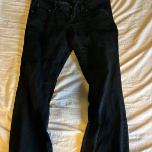 Lowaist bootcut jeans från Gina - Svarta bootcut jeans från Gina med låg midja. Snygga silvriga knappar på baksidan. Behöver tyvärr sälja mina favorit byxor för att dom blivit förstora💞