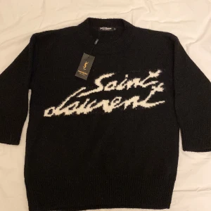 Svart stickad Saint Laurent tröja - Helt ny saint Laurent tröja som jag säljer då den tyvärr inte passade mig. Riktigt snygg tröja i mycket bra kvalité och skönt material. ALDRIG ANVÄND!  !!PRIS GÅR ATT DISKUTERA!!