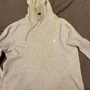 Ralph Lauren Hoodie - Säljer denna feta grå Hoodien från Ralph Lauren. Hoodien är in nyskick och har inga tecken på användningar eller slitage. Sitter riktigt bra på kroppen och är perfekt nu inför hösten. Skriv vid frågor eller funderingar. Välkommen!
