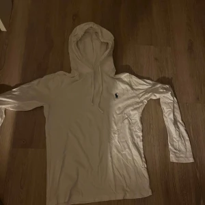 Vit hoodie från Polo Ralph Lauren XS - Vit hoodie från Polo Ralph Lauren i mjuk bomull. Väldigt bra skick inte annvänd mer än 3 gånger. Klassisk design med huva och snörning, långärmad och med den ikoniska lilla broderade loggan på bröstet. Perfekt för en chill och stilren look.