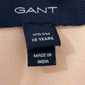 Ljusrosa långärmad skjorta från GANT - Snygg ljusrosa skjorta från GANT med klassisk krage och broderad logga på bröstet. Skjortan har långa ärmar och knappar framtill. Tillverkad i mjuk bomull som känns skön mot huden. Perfekt för dig som gillar stilrena och tidlösa plagg.