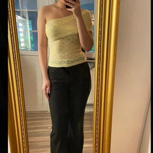 Ljusgul spetsig oneshoulder tubtopp - Säljer en ljusgul tubtopp med spets och oneshoulder-design. Aldrig använd!