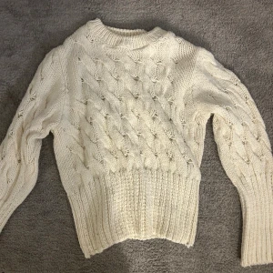 Vit stickad tröja från Gina Tricot - Supermysig vit stickad tröja från Gina Tricot med snyggt flätmönster och ribbade muddar. 