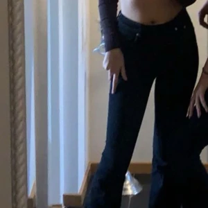 Svarta bootcut jeans - Snygga svarta jeans med bootcut-modell och låg midja. Perfekta för dig som vill ha en klassisk men trendig look. Jeansen har en figurnära passform upptill och utsvängda ben nertill. Mycket bra skick. 