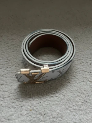 Vitt bälte - Snyggt vitt bäte med guldigt spänne.Den är 105 lång. Kan gå ner i pris vid snabb affär. Det är bara att fråga om du har några frågor.