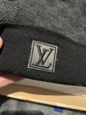 Svart stickad Louis Vuitton väst - Snygg svart stickad väst från Louis Vuitton med klassisk LV-logga framtill. Västen är tillverkad i mjuk ullblandning och har en stilren, enkel design som passar perfekt till streetwear eller en mer dressad look. Märkesetikett på insidan och exklusiv känsla.