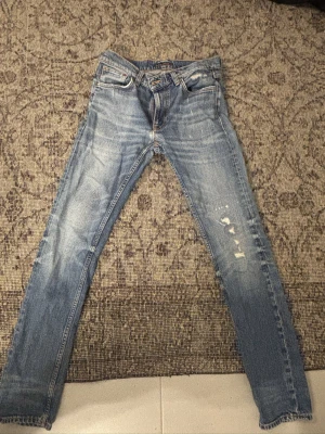 Nudie jeans slitningar  - Säljer mina unika och sällsynta Nudie jeans med riktigt snygga slitningar. Dem är lagade (bild 3) men det är en professionell lagning som blandas in perfekt looken. Storlek 30/34 men jag använt dem som en 30/32 och det har funkat bra för mig! Köptes för 3000 kr men säljer för 999kr pris kan såklart diskuteras vid snabb affär, skriv vid frågor