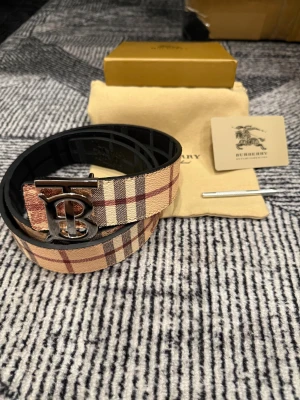 Beige/svart Bälte  - Säljer ett helt nytt bälte oanvänd, storlek 110 cm. Bältet har två färger då du kan vända märket ut och in väldigt simpelt. Fraktar snabbt inom 24h efter köp. Skriv gärna vid fler frågor eller bilder .
