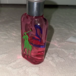 Ralph Lauren parfym rosa flaska - Cool parfym från Ralph Lauren med färgstark design och tydlig siffra 2 på flaskan. Perfekt för dig som vill sticka ut med en ikonisk look. Volym och ingredienser syns ej på bilderna.