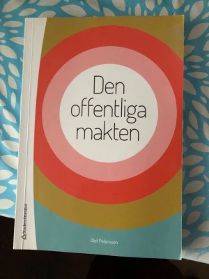 Den offentliga makten - Upptäck hur samhället styrs! Den här boken har en modern och färgstark design som gör den perfekt för dig som pluggar eller är nyfiken på politik och samhälle. Skriven av Olof Petersson och utgiven av Studentlitteratur.