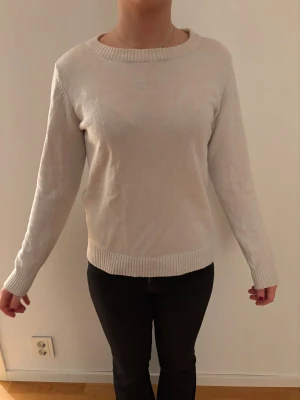 VILA Vit stickad tröja - En enkel och snygg beige stickad tröja med rund hals och ribbade muddar vid ärmslut och nederkant. Perfekt för dig som gillar en clean och stilren look. Långärmad modell som passar till jeans eller kjol.