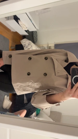 Beige trenchcoat från Esmara - Snygg beige trenchcoat från Esmara med klassisk krage och dubbelknäppning framtill. Jackan har långa ärmar med knappdetalj vid mudden och två fickor fram. Perfekt för dig som gillar stilrena och tidlösa plagg.