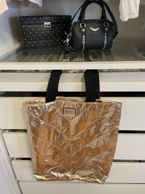 Victoria's Secret bag limited edition - Limited edition Victoria's Secret bag i rose gold. Svart tyghandtag med ett Victoria's Secret märke framtill. 