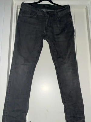 Jack & Jones Slim Glenn - Snygga mörkgrå jeans med smal passform och klassisk femficksdesign. Jeansen har en modern slim stil och är tillverkade i mjukt denim-material som sitter skönt hela dagen. Perfekta för dig som gillar en stilren look. Hör av er för mer.