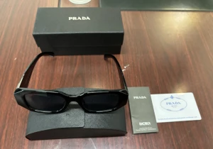 Prada solglasögon  - Helt nya och oanvända Prada solglasögon. Kommer i originalförpackning med allt som medföljer: box, fodral, putsduk, certifikat och booklet. Aldrig använda – endast öppnade för att ta bild på. Stilrena svarta bågar med mörka glas. Klassisk lyxig Prada-design som passar både dam och herr.  Märke: Prada  Skick: Helt nya, oanvända Färg: Svart / Black Medföljer: Originalbox, fodral, certifikat, booklet