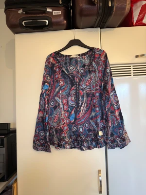 Odd molly blus  - Säljer en otroligt vacker blus med en bottenfärg i mörkblå. Den har ett superfint detaljerat mönster i bland annat rött, blått, svart och vitt. Från märket Odd Molly. Storlek 2 som enligt deras storleksguide motsvarar en M. Mycket fint skick, jag hittar inga synliga anmärkningar eller defekter. 