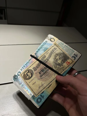 Maison Margiela inspirerad passfodral i skinn - Säljer ett handgjort passfodral  i äkta skinn som är inspirerat av Maison Margiela 11 dollar wallet. Sedlarna på Fodralet har jag limmat på förhand och alla är fullt äkta ädlre sedlar. Det finns bla svenska, polska, turkiska, australiska och Jamaica. Fodralet är även sprayat i vatten tät spray för håplbarhet. Den har flera fack för kort och dokument, perfekt för att hålla passet, viktiga papper och kort tex EU hälsokort osv. 