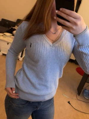Ljusblå stickad tröja från Ralph Lauren - Snygg ljusblå stickad tröja från Ralph Lauren med v-ringad hals och kabelstickat mönster. (Storlek M men passar även S osv)🩷
